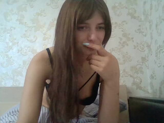 AlinaKat busty cam girl caresses her lips.